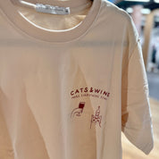 Off-white sweatshirt with 'CATS & WINE MAKE EVERYTHING FINE' text and graphics on a hanger.